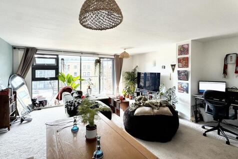 A bright and spacious living room featuring lar...