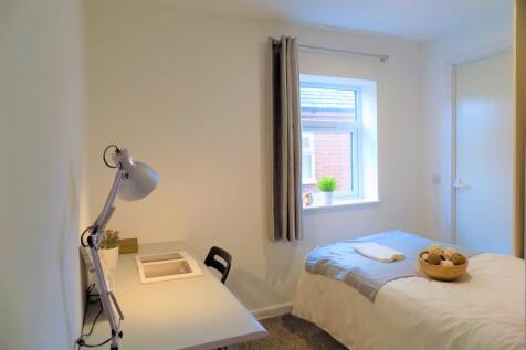 Bright and tidy single bedroom featuring a cozy...