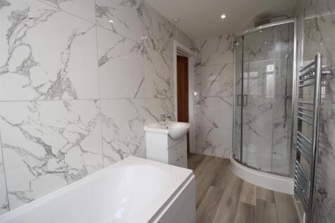 Elegant marble-effect tiles and a modern tub...