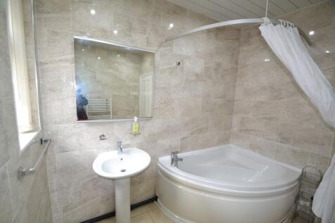 Bright and clean bathroom featuring a corner ba...