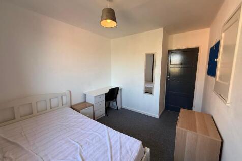 Bright, simply furnished bedroom with a double ...