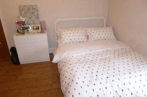 Cozy double bedroom with a neatly made bed, sim...