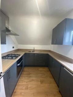 Modern U-shaped kitchen with grey cabinets, woo...