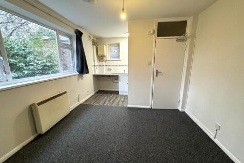 Bright, simply presented bedroom with a large w...