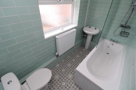 Modern bathroom with stylish tiles and a bathtu...