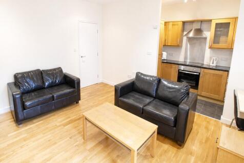 Bright open-plan lounge with sleek leather sofa...