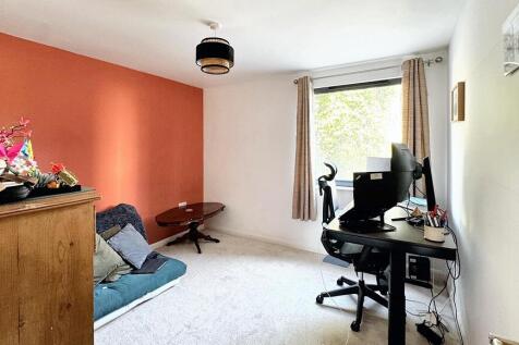 A spacious and well-lit living room featuring a...