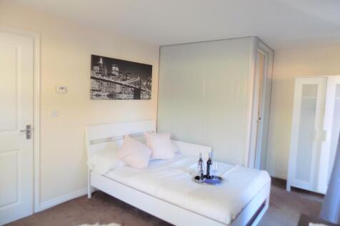 Bright, modern bedroom with a double bed dresse...