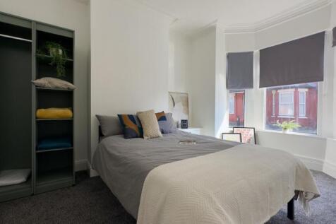 A bright and spacious double bedroom with moder...