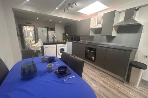 Modern shared kitchen with dining table and isl...