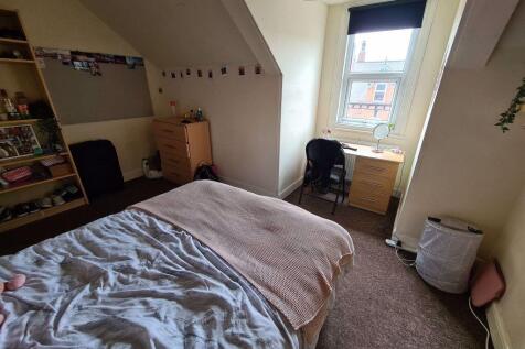 A spacious and inviting bedroom with a large be...