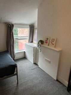 A cozy bedroom featuring a window with natural ...