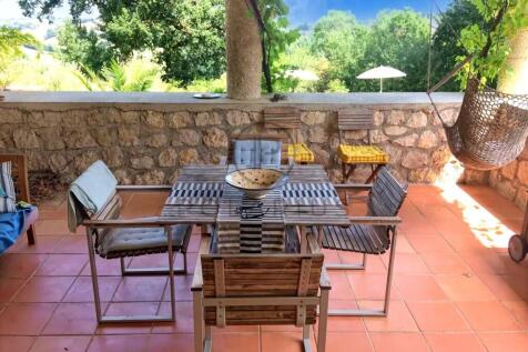 A cozy outdoor patio with a wooden dining set on t