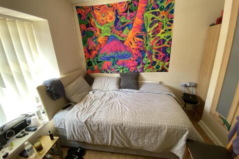 Bright bedroom with large bed and colorful art...