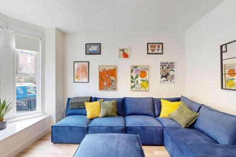 A bright, spacious living room featuring a comf...