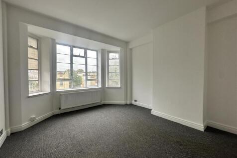 Bright bedroom with large bay window and neutra...