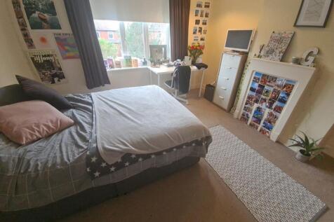 A cozy bedroom featuring a large double bed wit...