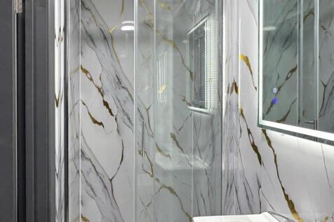 Modern bathroom with a glass-enclosed shower, s...