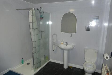 Bright, modern bathroom with a glass-enclosed c...