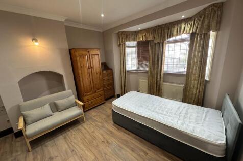 Spacious bedroom with sofa and classic bay wind...