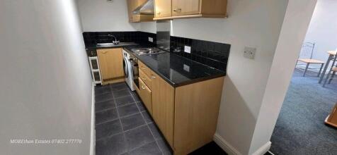 Modern kitchen with sleek dark worktops...