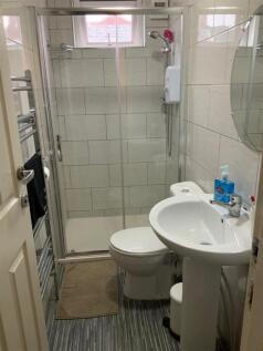 Bright, modern tiled bathroom with a walk-in gl...