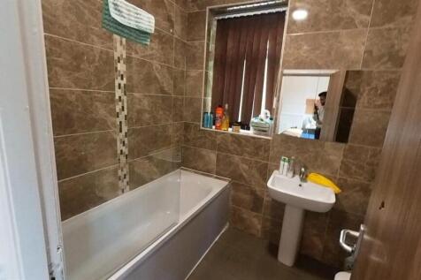 Modern tiled bathroom with full-sized bathtub...