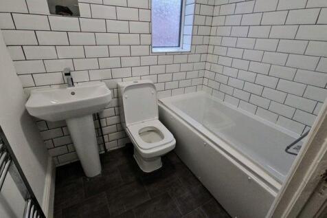 Modern tiled bathroom with bath and towel rail...