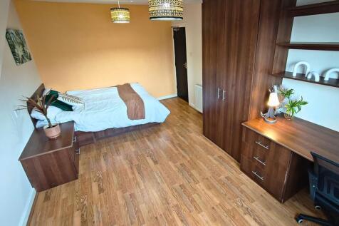 Bright, well-furnished bedroom featuring a comf...