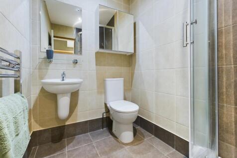 A modern and tidy bathroom featuring a shower a...