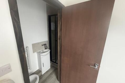 Compact ensuite with modern sink and shower...
