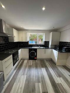 Modern and sleek kitchen with white cabinetry, ...