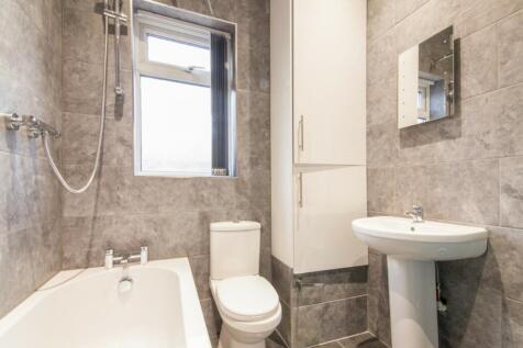 A modern bathroom featuring elegant grey tiles,...