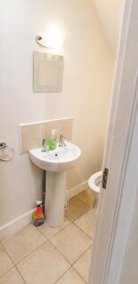 Bright and tidy cloakroom with neutral tiling....