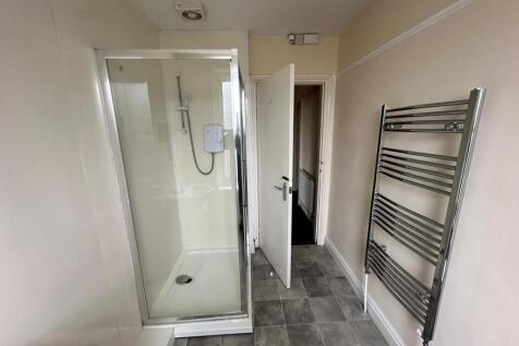 Clean, modern bathroom with a fully enclosed sh...