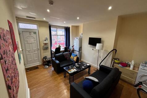 Well-lit communal living area with two black so...