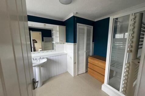 Spacious bathroom with modern blue accent walls...