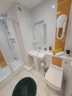 Bright, modern bathroom with a glass shower enc...