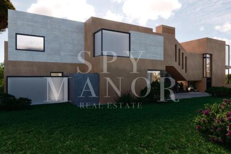 Modern luxury house architecture featuring concrete elements and large windows for sale in Algarve, Portugal.