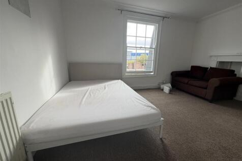 Spacious bedroom with double bed and sofa area...