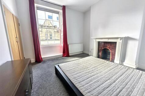 Spacious bedroom with large window and fireplac...