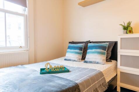 Bright, neatly styled double bedroom with a com...