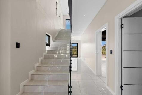 Front door entrance with staircase up to three ensuite bedrooms. Direct access from garage.