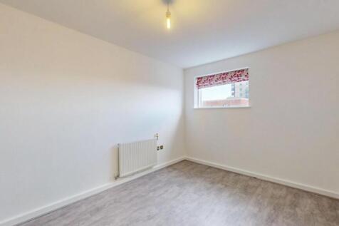 A simple, clean room with light grey flooring, ...