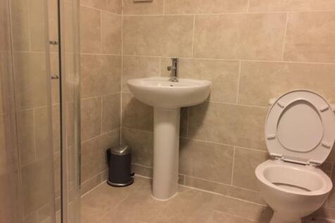 Neutral tiled bathroom with a pedestal sink, en...