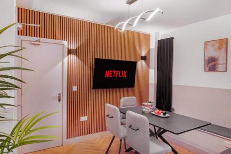 Stylish modern dining area with a feature TV wa...