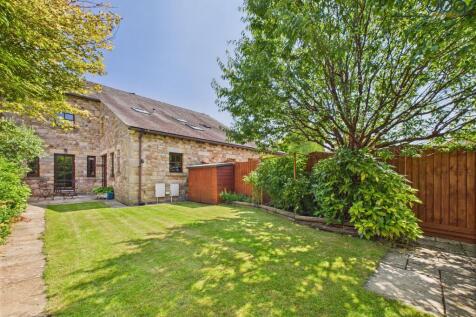 Spacious rear garden with mature plants and boarders