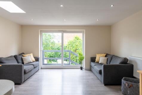 Bright, modern living room with matching grey s...