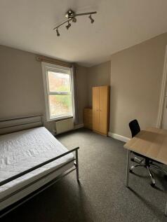 Bright, neutral double bedroom with a metal bed...