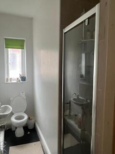 Compact bathroom with a modern corner shower en...